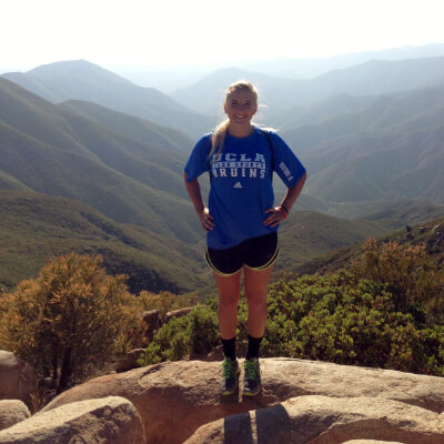 hiker posing in front of mountainous background