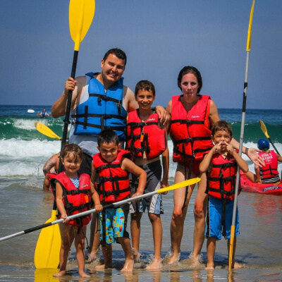 family holding kayak paddles on la jolla shores