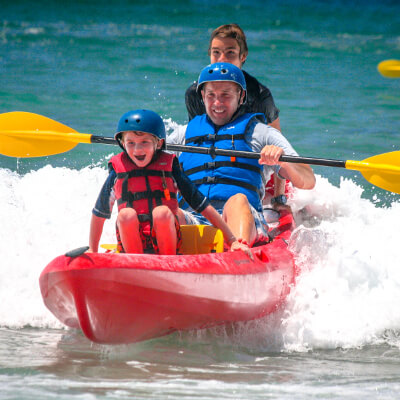 Father and son ride a wave near La Jolla
