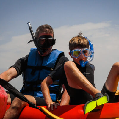 Two people jumping off the kayak on a kayak and snorkel tour in La Jolla